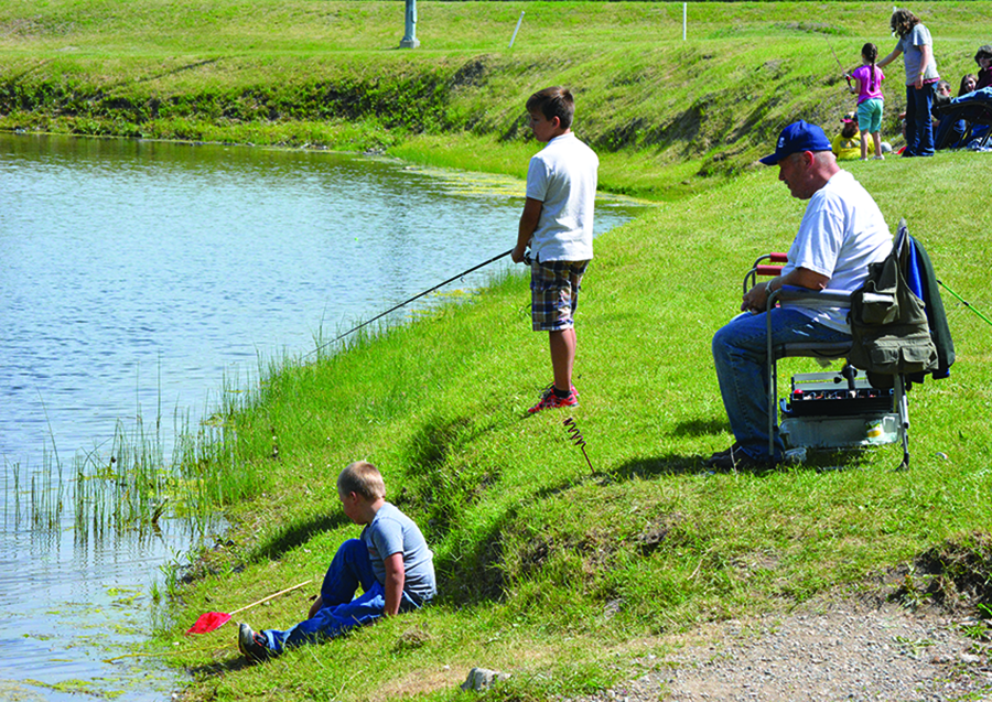 Craig Godlonton and his two grandsons enjoying the beautiful weather last Saturday at the Magrath Fish Pond for the Annual Fun Fish Day put on by the Magrath Rod and Gun Club.
